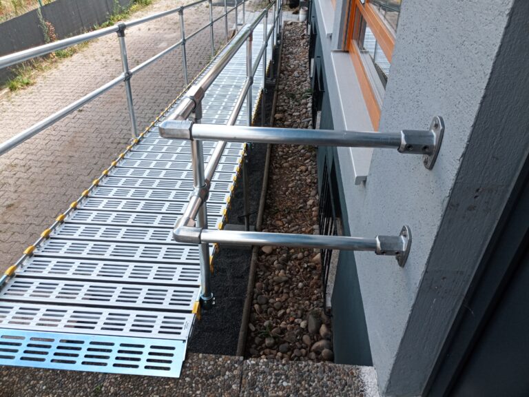 Geländer einer barrierefreien Rollstuhlrampe vor Gebäude